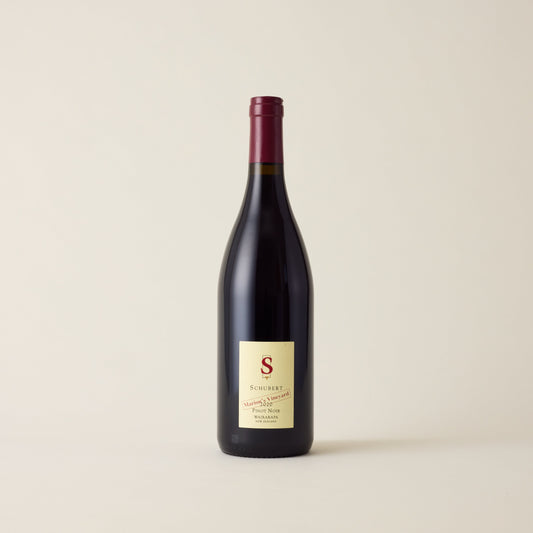 Red wine bottle with Pinot Noir wine inside. A cream label with Schubert logo. A red neck label.