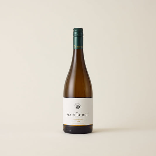 White wine bottle with Chardonnay wine inside. A white label with The Marlborist logo. A green screwtop and marlborist logo on neck label.