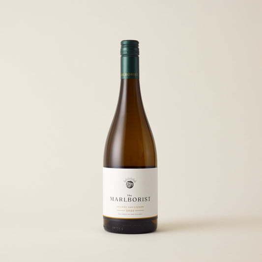 White wine bottle with Sauvignon Blanc wine inside. A white label with The Marlborist logo. A green screwtop and marlborist logo on neck label.