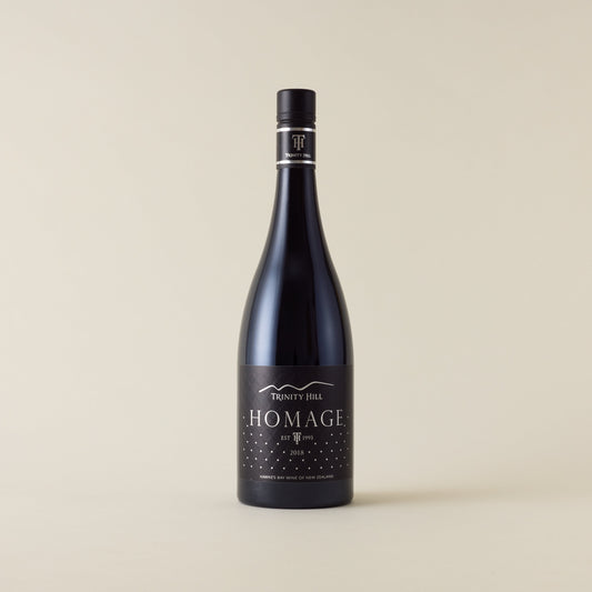 Red wine bottle with syrah wine inside. A black label with Homage logo. A black screwtop and neck label.