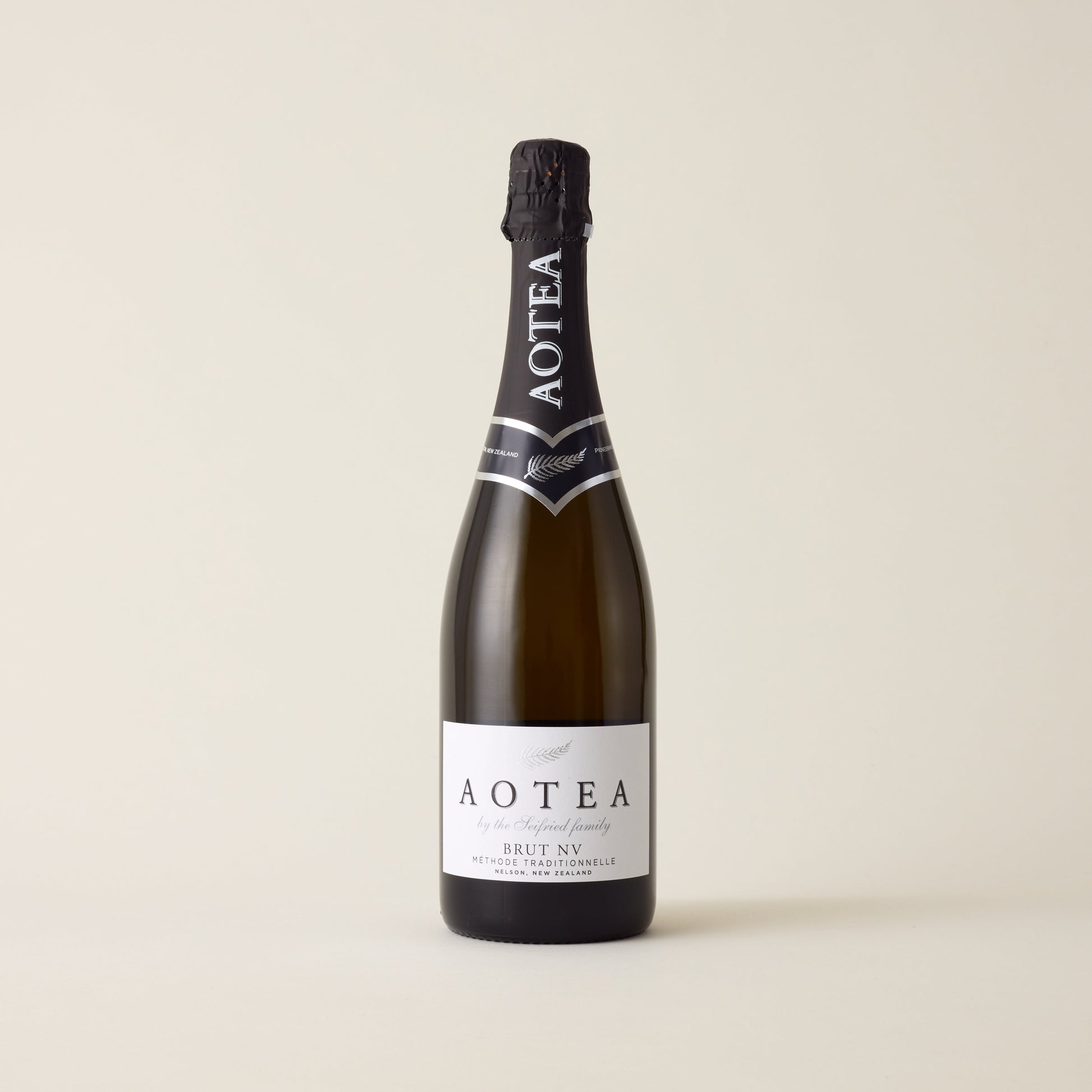 Sparkling wine bottle with Chardonnay and Pinot Noir wine inside. A white label with Seifried logo. A black foil cap and neck label.