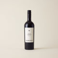 Red wine bottle with Merlot Cabernet wine inside. A White label with Radburnd logo. A black screwtop and neck label.