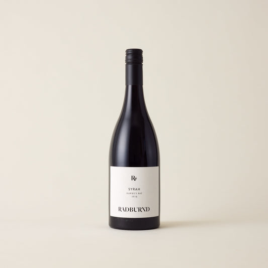 Red wine bottle with Syrah wine inside. A White label with Radburnd logo. A black screwtop and neck label.