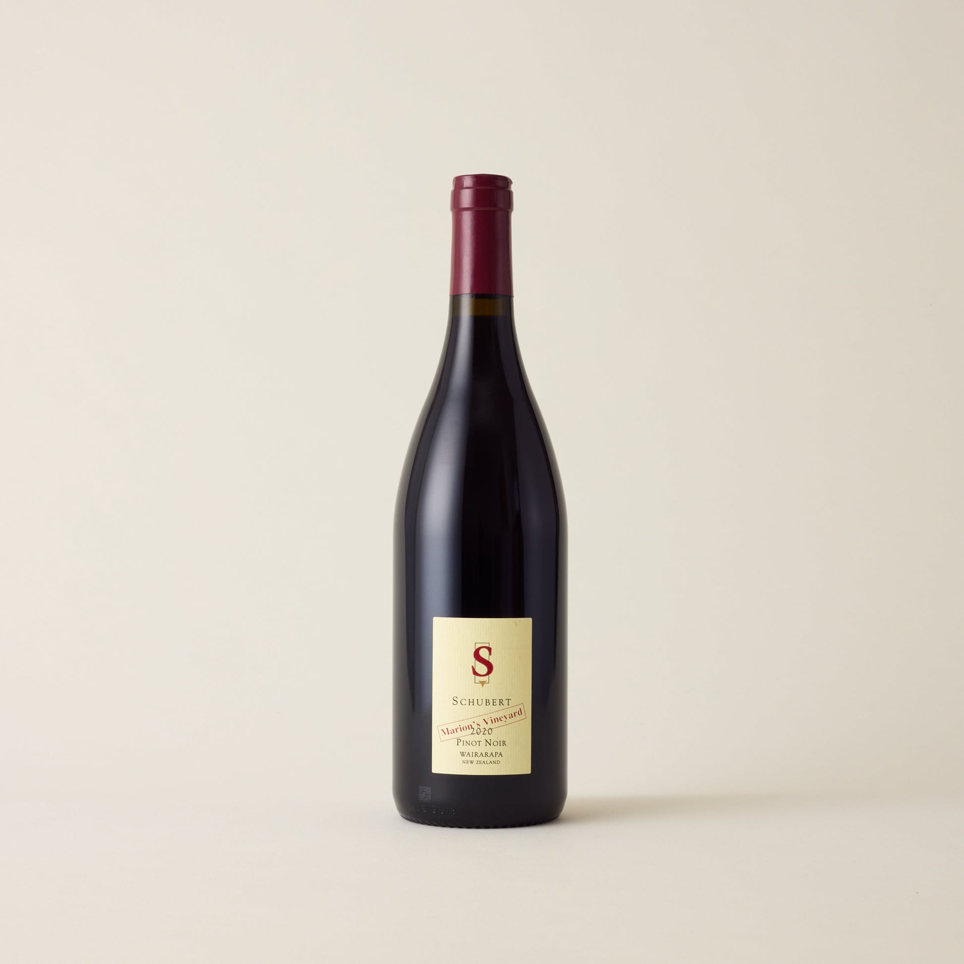 Red wine bottle with Pinot Noir wine inside. A cream label with Schubert logo. A red neck label.