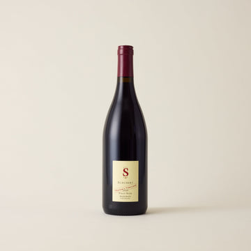 Red wine bottle with Pinot Noir wine inside. A cream label with Schubert logo. A red neck label.
