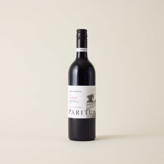 Red wine bottle with Merlot Cabernet wine inside. A White label with Paritua logo. A black screwtop and neck label.
