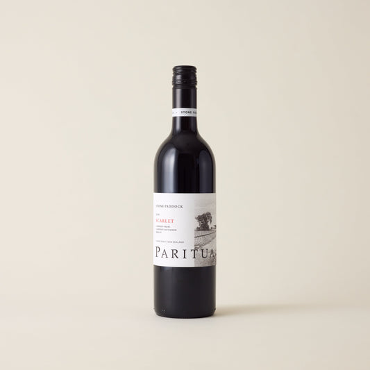 Red wine bottle with Merlot Cabernet wine inside. A White label with Paritua logo. A black screwtop and neck label.