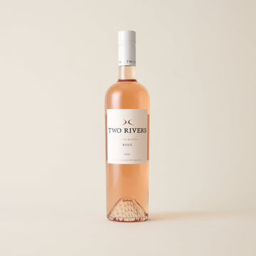 Rose wine bottle with Syrah wine inside. A white label with Two Rivers logo. A white screwtop and logo on neck label.