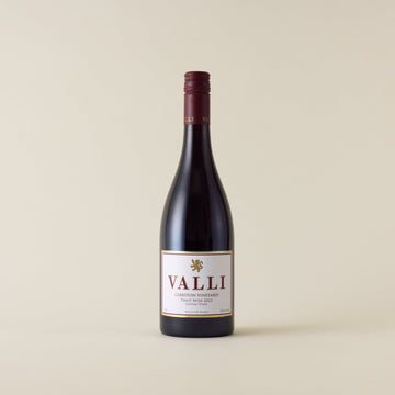 Red wine bottle with pinot noir wine inside. A white label with Valli logo. A burgundy screwtop and Valli logo on neck label. 